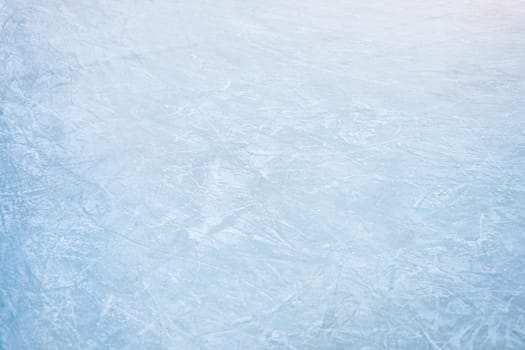 Icy background on rink with visible traces of skating, showcasing the essence of winter sport. Texture of ice on skating rink visible from top view, displaying sheet of scratched ice.