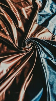 Flowing smoothly and elegantly, the golden silk fabric creates a luxurious background with a soft, graceful feel, shimmering with sophistication and glamour