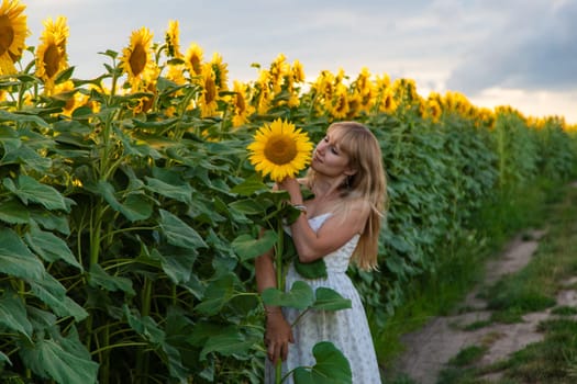 Woman in sunflowers in a field. Selective focus. nature.