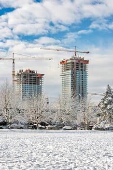 New high-rise residential buildings under construction on bright winter day.