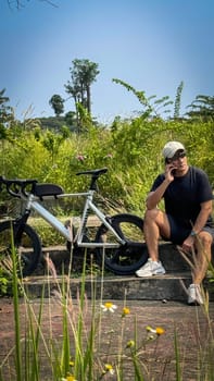 Healthy lifestyle, bicycle sport and exercise, a man in casual sportswear rides a bicycle on a sunny day surrounded by lush greenery, the image captures a sense of relaxation and outdoor adventure, good for health and sport article or content creation