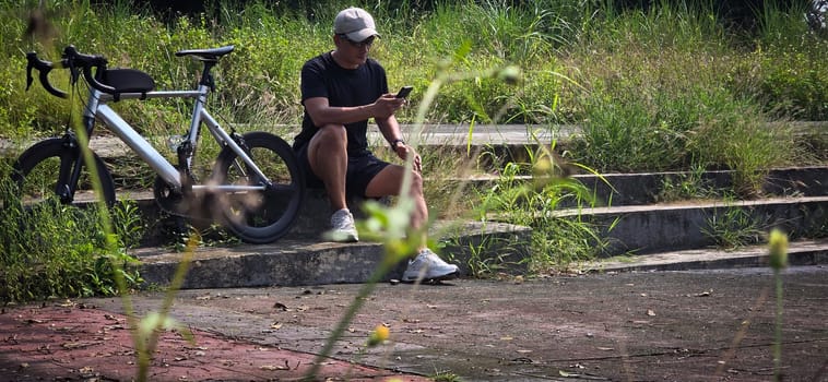 Healthy lifestyle, bicycle sport and exercise, a man in casual sportswear rides a bicycle on a sunny day surrounded by lush greenery, the image captures a sense of relaxation and outdoor adventure, good for health and sport article or content creation