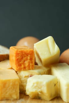 Cheese cubes green, yellow and red color on chopping board .