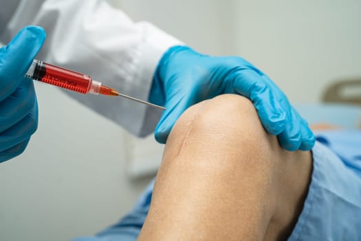 Asian doctor inject Hyaluronic acid platelet rich plasma into the knee of senior woman to walk without pain.