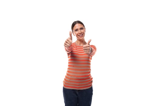 a pretty young adult woman with black hair dressed in an orange sweater is actively gesturing on a white background with copy space.