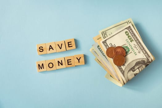 Money in international currency, dollars, euro coins lie on a blue background. Lettering save money