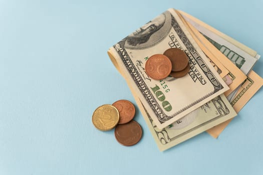 Multicurrency banknotes, euro coins, dollars on a blue background. The concept of the world economy during the crisis