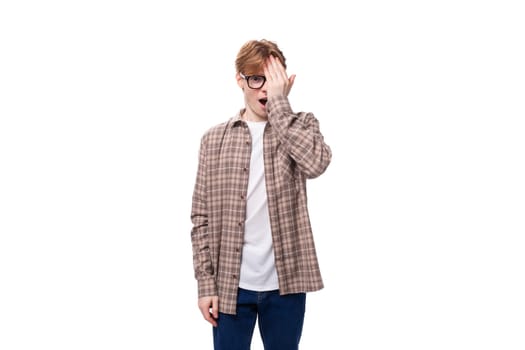 young stylish man with red hair with glasses on a white background.