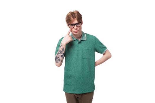 young successful confident european red-haired man dressed in a green t-shirt on a white background.