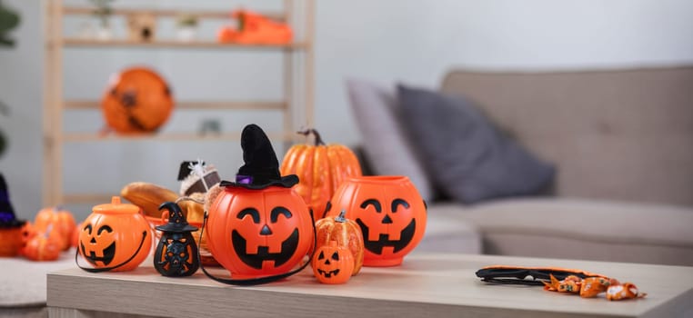 Halloween background. An orange pumpkin placed on a wooden table in the living room. Festive home decorating ideas..