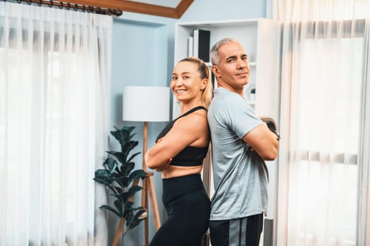 Athletic and sporty senior couple portrait in sportswear with standing posture as home exercise concept. Healthy fit body lifestyle after retirement. Clout