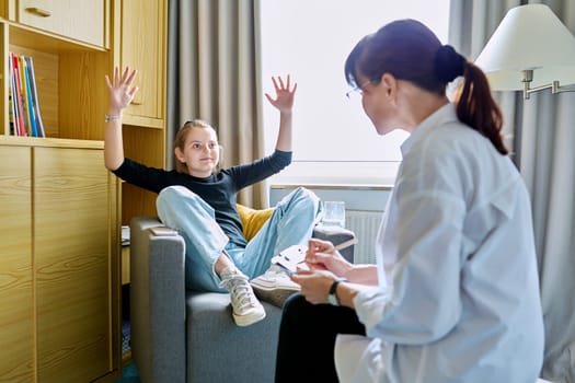 Girl child 10 years old at therapy session with psychologist. School counselor talking to child, listening, helping with problem. Mental health, childhood, schoolchildren, psychology, psychotherapy