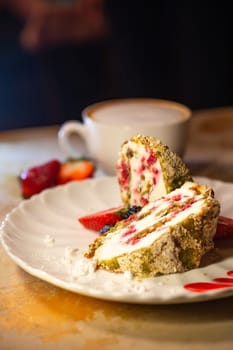 meringue roll cut on a white plate on the table.