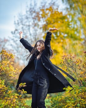 Happy girl spinning in the autumn park