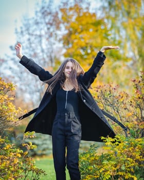 Happy girl spinning in the autumn park