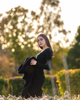 Beautiful girl posing in the sunshine in an autumn park