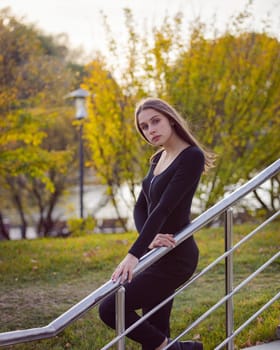 Beautiful girl posing on the steps in an autumn park