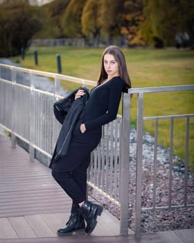 A girl poses on a bridge in a city park