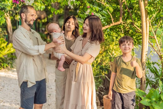 Happy couple in their 40s, surrounded by adult children, cradle a newborn in a sunlit park. Love, family, and generations in harmony.