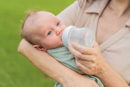Mother giving to drink water baby from bottle, closeup.