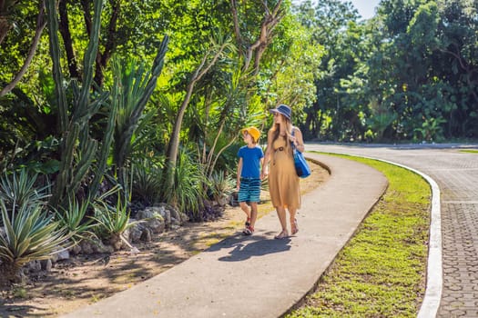 Expectant mother and her son enjoying a leisurely stroll in the park, cherishing precious moments amidst nature's beauty.