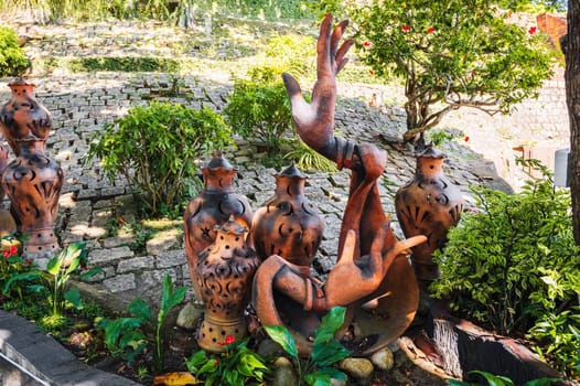 Vintage clay jugs and vases decorate the Asian garden at the pagoda in summer in Asia
