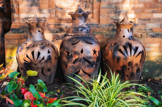 Vintage clay jugs and vases decorate the Asian garden at the pagoda in summer in Asia
