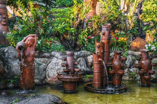 beautiful pond with fountains and statues on a pagoda in Vietnam in Asia in summer