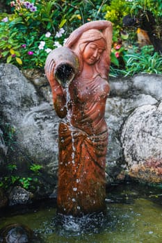 statue of a woman with a jug in a fountain on a pagoda in Asia