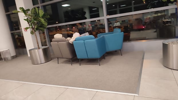 October 26, 2024 Prague Czech Republic, Vaclav Havel Airport, people tourists relax in chairs in the lobby waiting for a flight. High quality photo