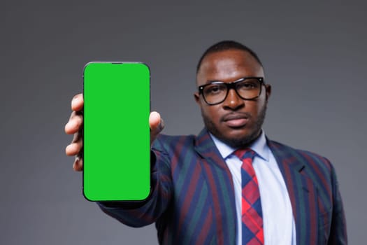 A man holding a green screen phone with a formal attire, perfect for stock footage or creative projects, space for text