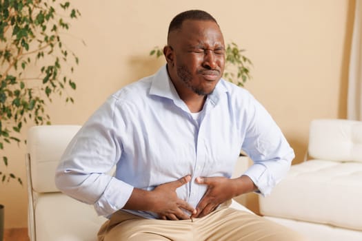 Intestinal inflammation. Irritable Bowel Syndrome. Man touching stomach, suffering painful of stomachache, gastrointestinal system desease cause of stress from work. Health insurance care concept