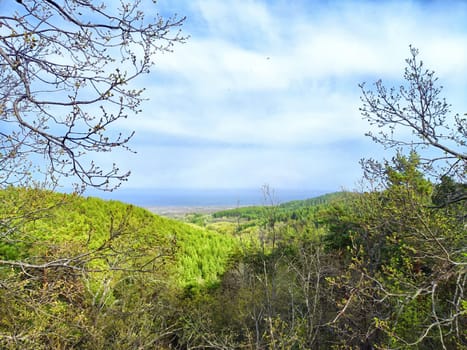Lush green hills stretch into the distance beneath a partly cloudy sky.