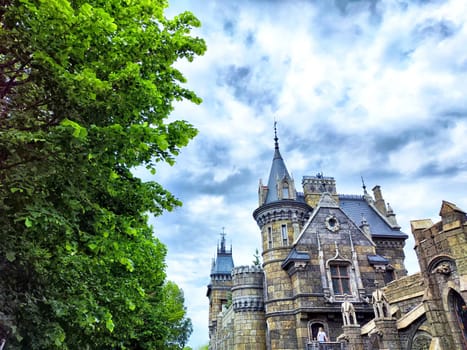 A stone castle with tall towers and cloudy sky