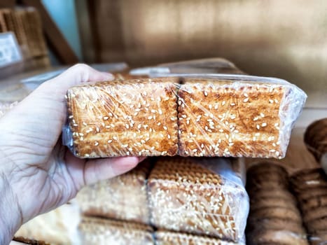 A person selects a bag of delicious cookies while shopping at a local store. Difficult balancing treats with a healthy lifestyle choice