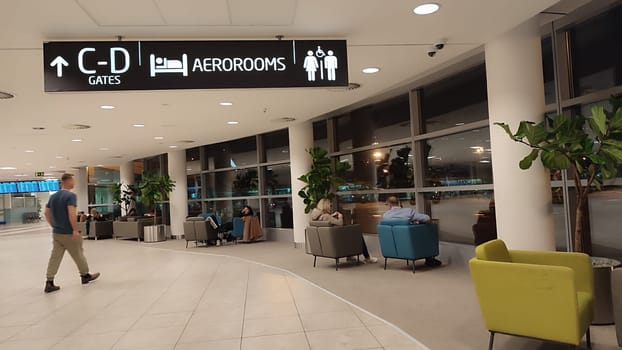 October 26, 2024 Prague Czech Republic, Vaclav Havel Airport, people tourists relax in chairs in the lobby waiting for a flight. High quality photo
