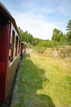A picturesque view from the steam train from bryrup to vrads in denmark train traveling through lush greenery and peaceful countryside. The image captures the serenity and beauty of nature along a winding railway path.