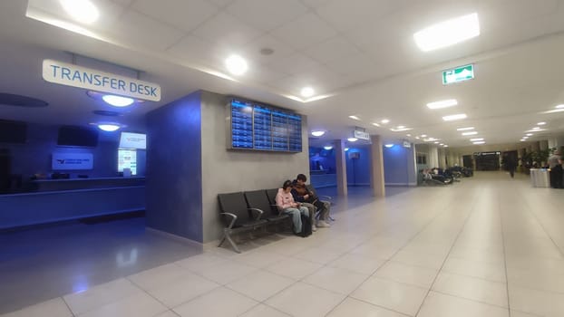 October 26, 2024 Prague Czech Republic Europe, Vaclav Havel Airport, people tourists in the lobby waiting for a flight,two teenagers sitting with mobile phones . High quality photo