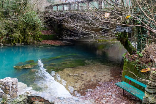 Small blue lake surrounded by mountains with clear water reflecting the natural landscape