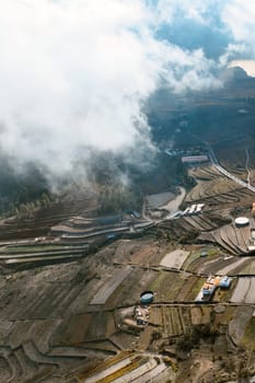 Dramatic view of a beautiful village and terraces with vineyards of Vilaflor, Tenerife Canary Islands, scenic view from above from a drone of a sunny picturesque valley and clouds.