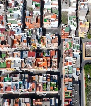 Top view from a drone of bright colored houses and roofs in Tenerife, Canary Islands on a sunny day, a small village on the Atlantic coast.