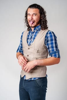 Man making a silly face with tongue out in casual attire against a neutral background close up