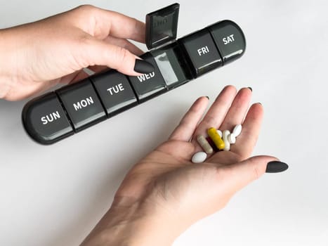 Weekly pill organizer and assorted supplements for daily health routine.