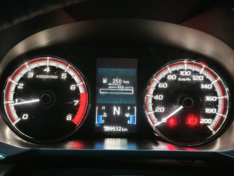 A car dashboard with a digital display, ECO mode indicator, and a tachometer indicator.