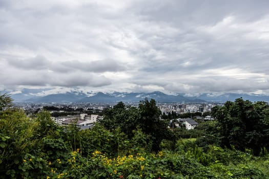 NAGANO, JAPAN - SEPTEMBER 19, 2024: An aerial view over the beautiful town of Nagano in Nagano Prefecture. Surrounded by mountains on a stormy warm autumn morning.