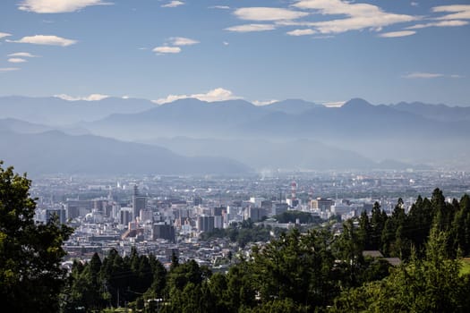 NAGANO, JAPAN - SEPTEMBER 20, 2024: An aerial view over the beautiful town of Nagano in Nagano Prefecture. Surrounded by mountains on a clear warm autumn morning.