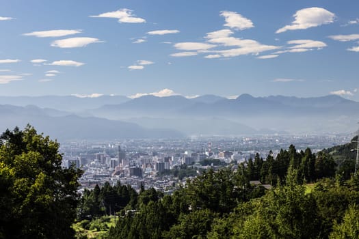 NAGANO, JAPAN - SEPTEMBER 20, 2024: An aerial view over the beautiful town of Nagano in Nagano Prefecture. Surrounded by mountains on a clear warm autumn morning.
