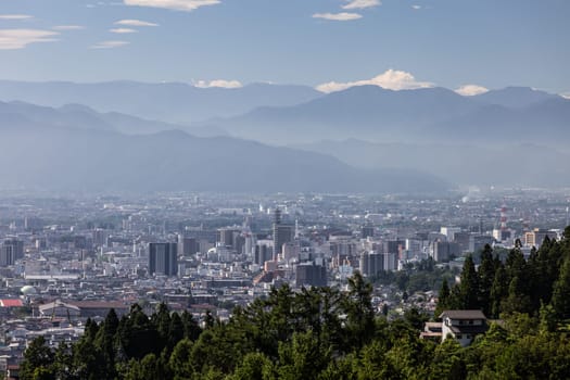 NAGANO, JAPAN - SEPTEMBER 20, 2024: An aerial view over the beautiful town of Nagano in Nagano Prefecture. Surrounded by mountains on a clear warm autumn morning.