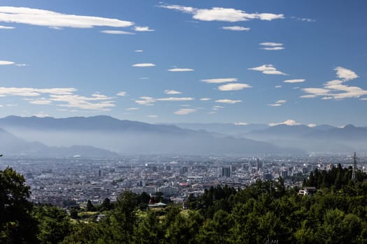 NAGANO, JAPAN - SEPTEMBER 20, 2024: An aerial view over the beautiful town of Nagano in Nagano Prefecture. Surrounded by mountains on a clear warm autumn morning.