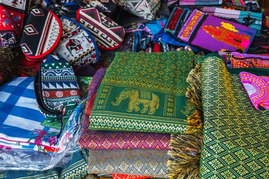 Colorful bags and various textiles on the counter at a street bazaar in Vietnam in Asia